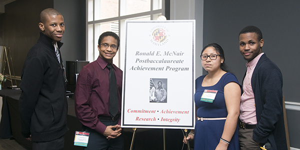 4 McNair students at  a poster session